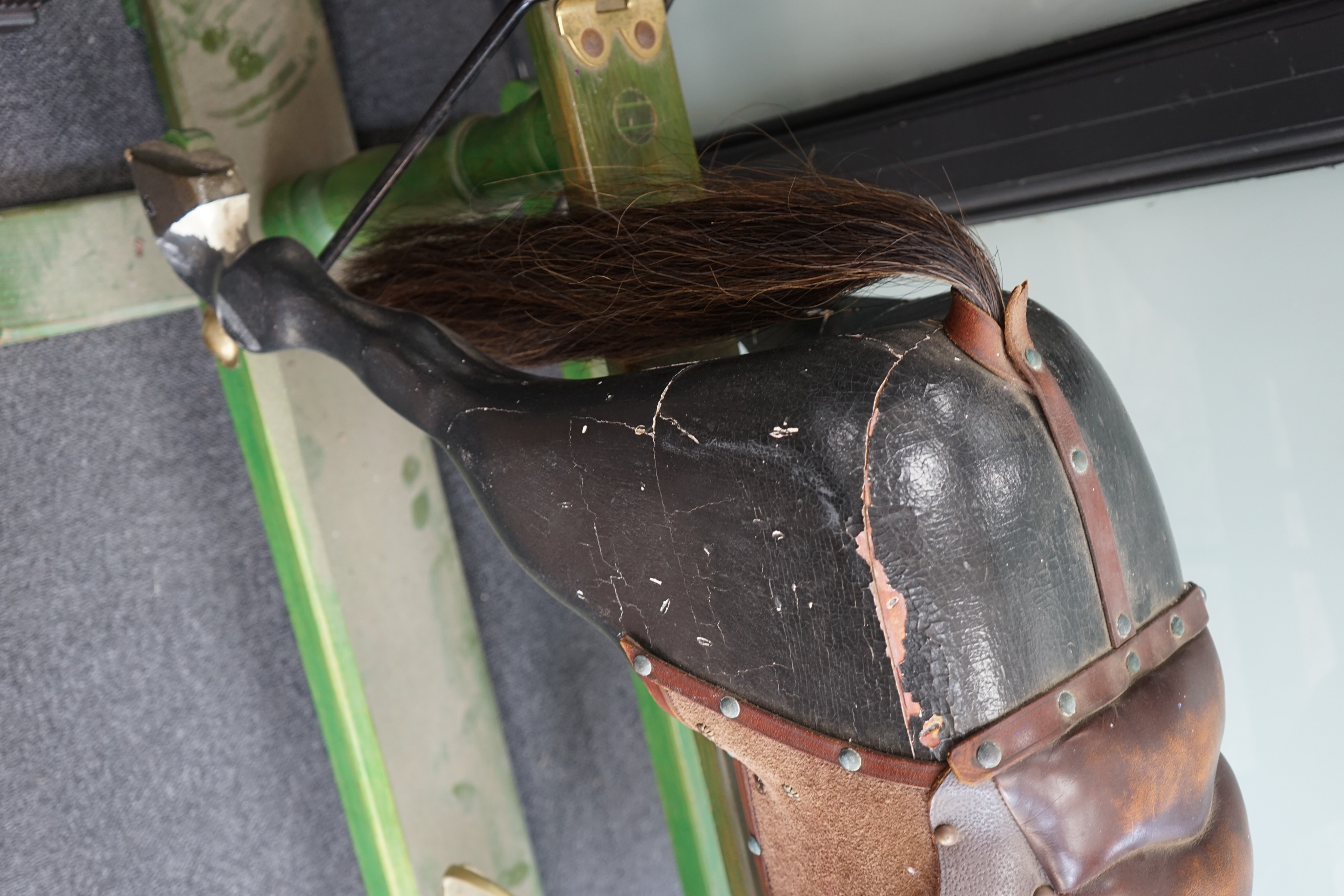 An early 20th century painted carved wood rocking horse on pine safety frame, length 132cm, height 107cm